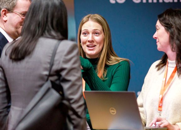 Delegates speaking with Optimus education at a conference.